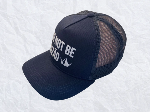: Boné trucker azul marinho com tela traseira e estampa frontal irreverente “DO NOT BE CUZÃO”. Estilo leve e atitude nas ruas.